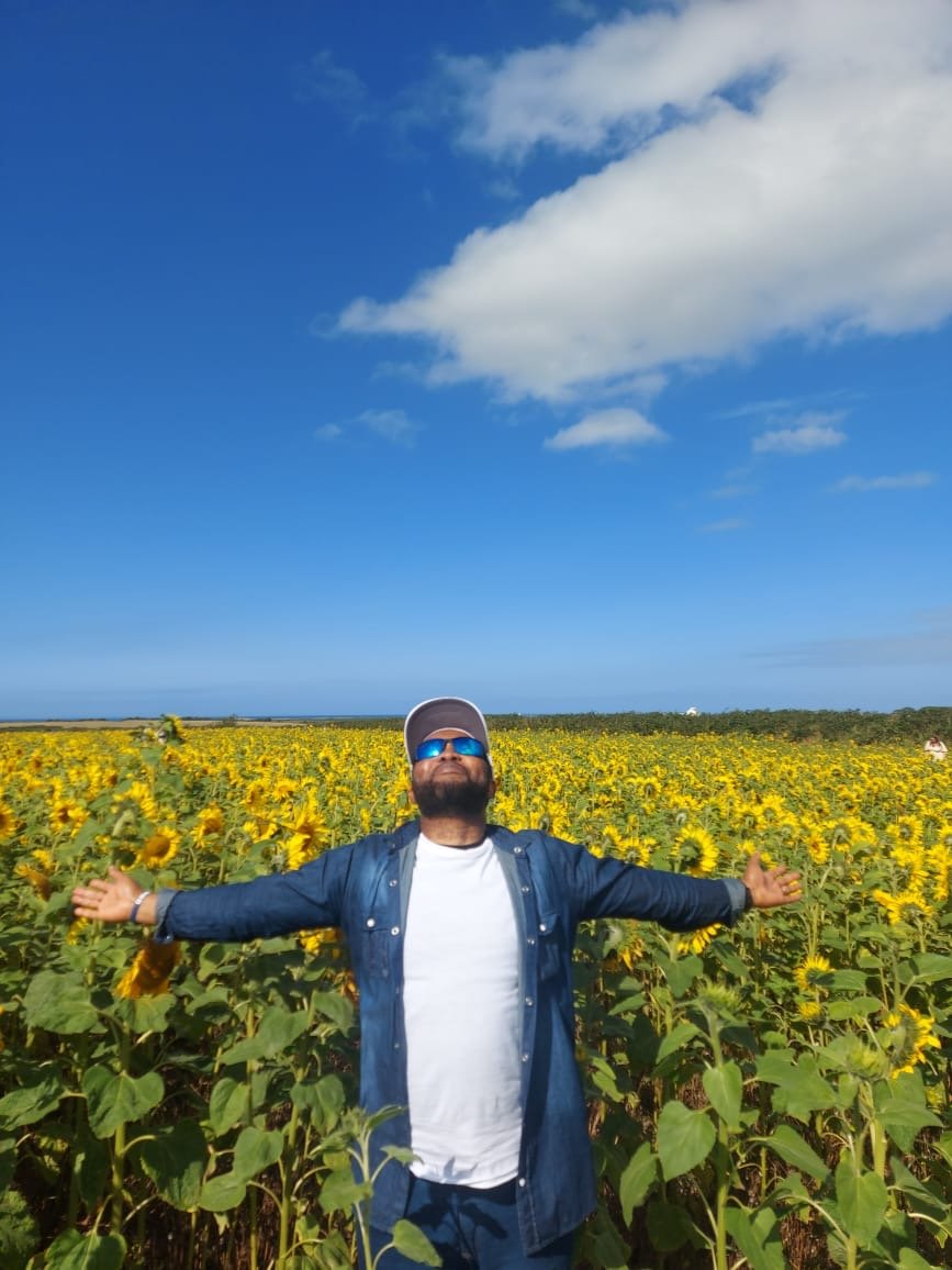 John Oseyili in a sunflower field